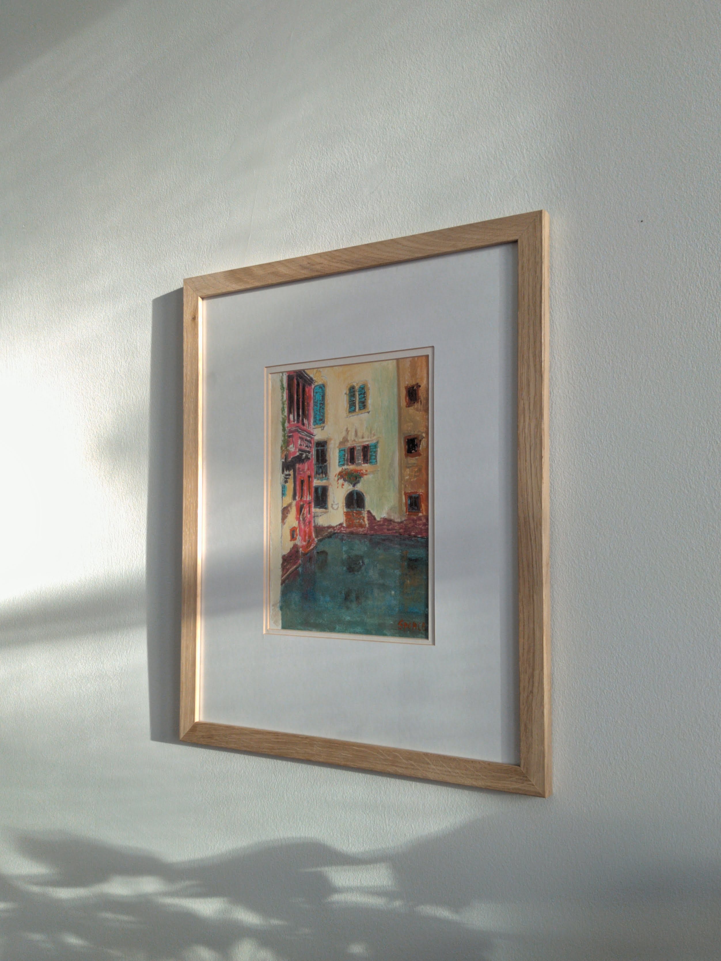A mid century modern framed colourful vintage painting of the Venice canals on a white wall.