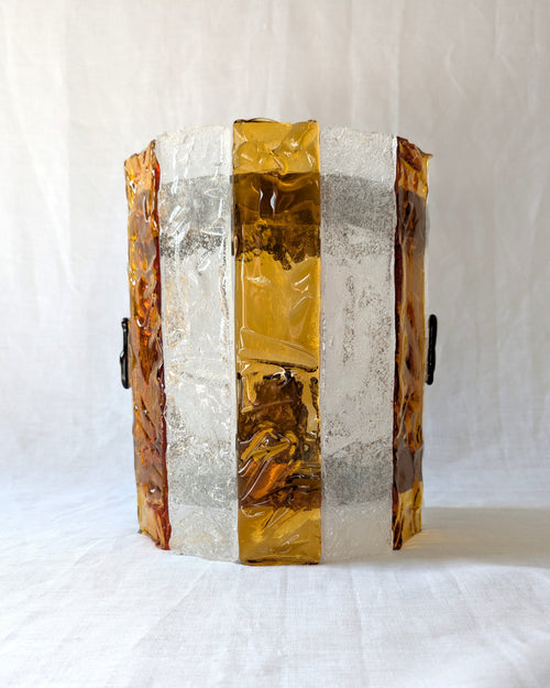 A vintage mid century modern 1970s Carlo Nason for Mazzega rectangular wall sconce with textured amber and clear striped Murano glass panels on white linen surface.