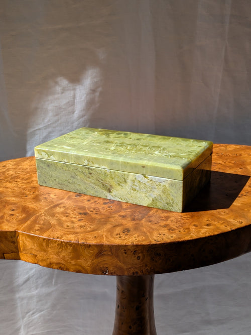 An antique green marble decor box by Henry Griffith & Sons circa 1893 - 1899 on a Hollywood regency style burl wood table. This rare Victorian decor box, made from hand carved solid Italian marble similar to onyx or jade, can be used as a trinket box, jewellery holder or cigar box and would be a beautiful addition to a vintage eclectic, mid century modern, minimalist, modernist, maximalist, baroque or art deco home interior schemes.