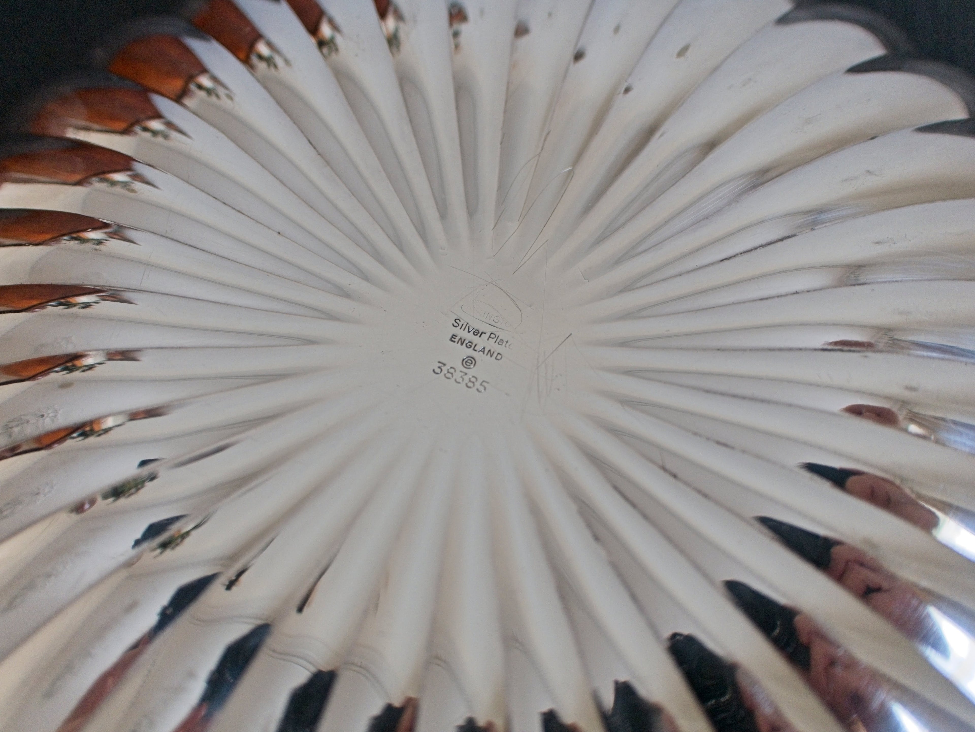 Close-up of a scalloped silver bowl with Elkington makers mark facing upwards.