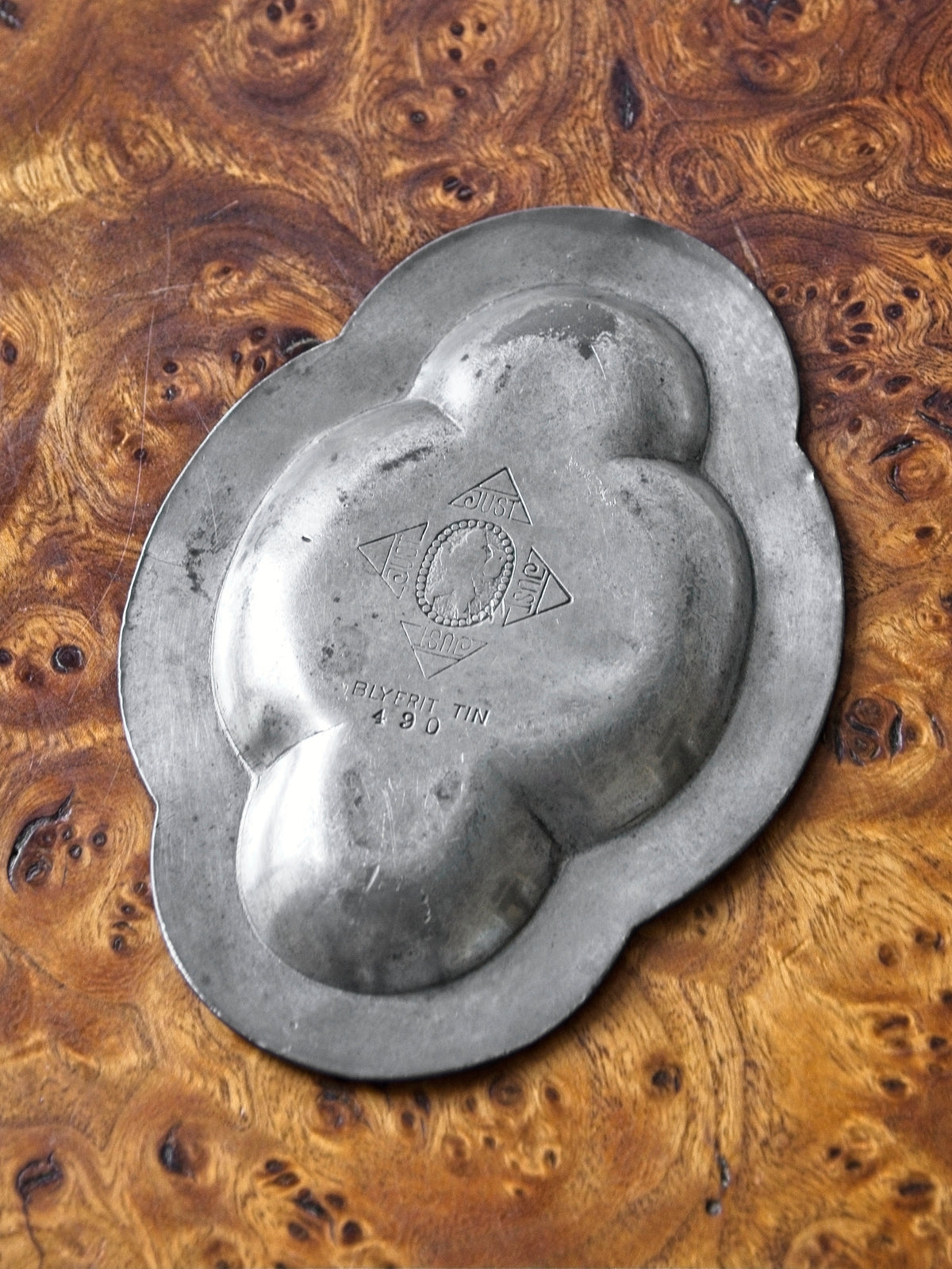 A vintage art deco pewter ring dish by Just Andersen for GAB (Guldsmedsaktiebolaget) Sweden on an antique burl wood table. This bijou floral shaped 1920s modernist trinket dish has four rounded petals, is engraved on the base with the distinctive Just Andersen x GAB collaborative makers mark, the model number '490' and would make an interesting addition to mid century modern, retro, baroque, modern vintage and minimalist home interiors.