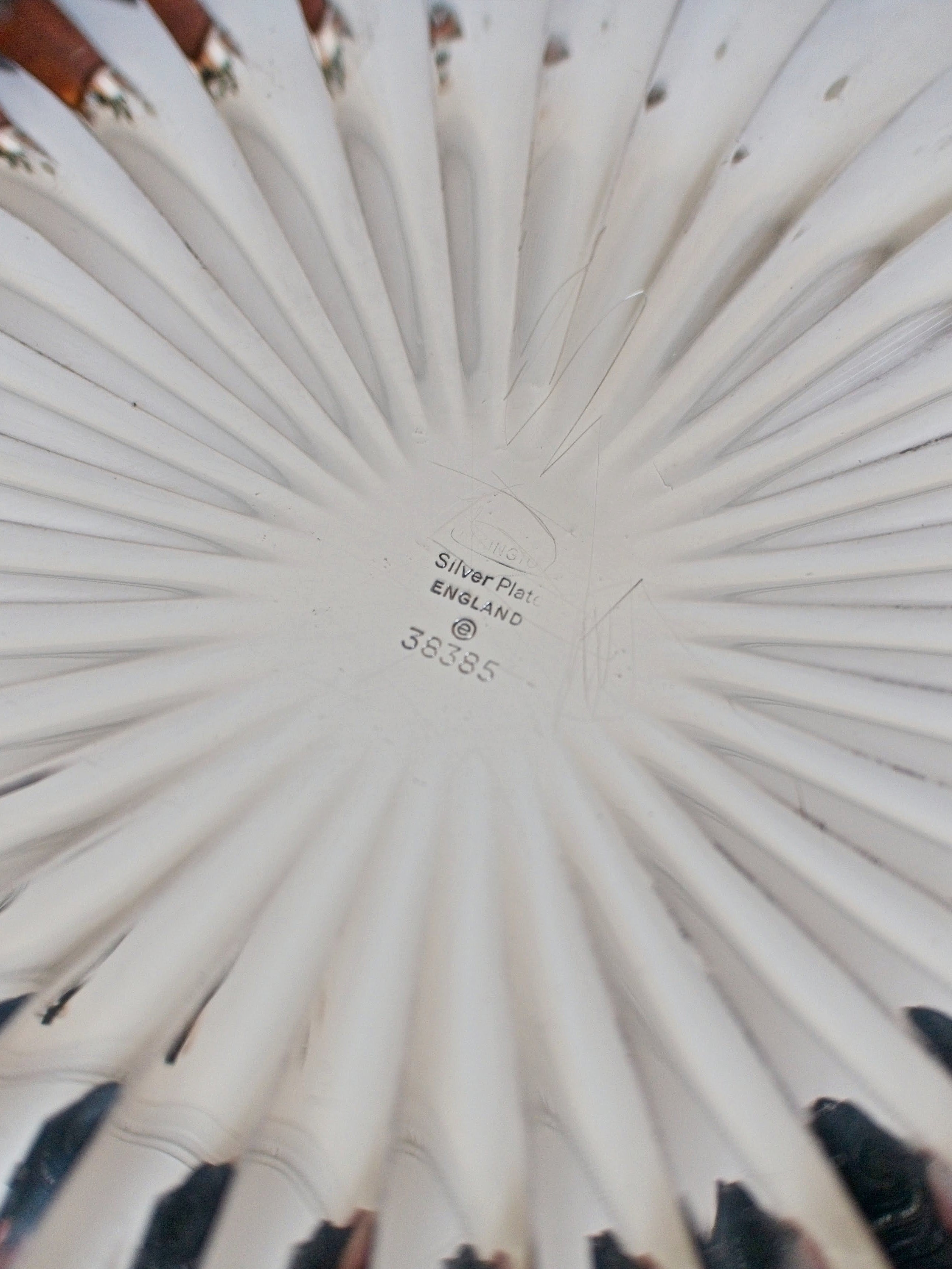 Close-up of a vintage scalloped silver bowl with an Elkington & Co Birmingham engraved makers stamp facing upwards.